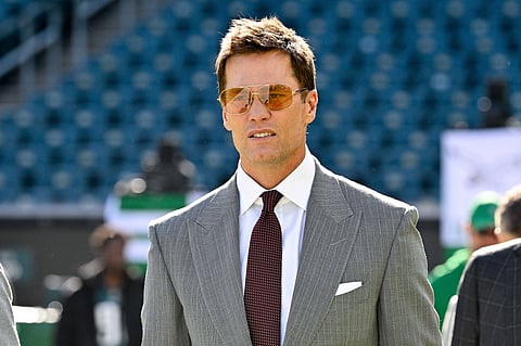 Tom Brady walks onto a field