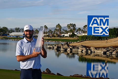 Scottie Scheffler holds the American Express trophy