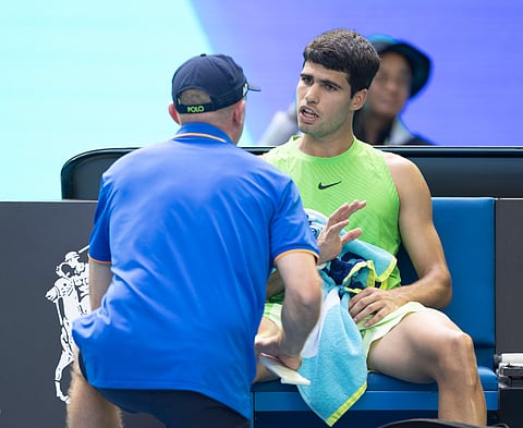 Carlos Alcaraz receives treatment during the match