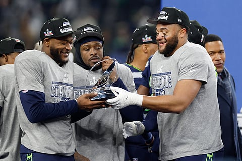 Seattle Seahawks players admire the George Halas Trophy