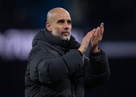 Pep Guardiola applauds the away fans at Anfield