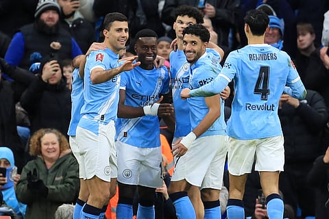 Marc Guehi celebrates with his teammates after scoring against Salford City