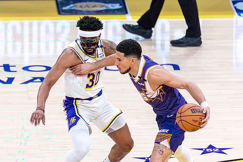 Devin Booker drives past with the ball 