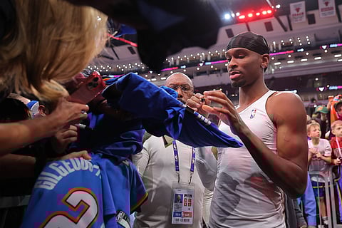 Shai Gilgeous-Alexander signs autograph after match