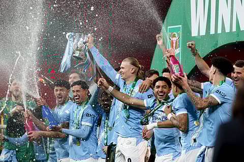 Manchester City team pose with the trophy