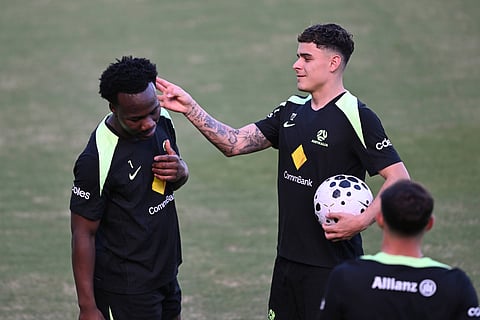 Alex Robertson flicks the ear of Nestory Irankunda during training