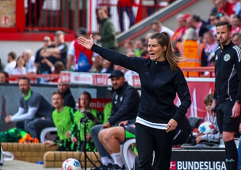 Marie-Louise Eta reacts from the touchline against VfL Wolfsburg