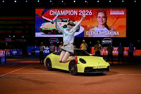 Elena Rybakina poses with the trophy and Porsche