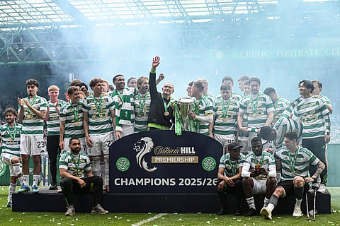 Celtic players pose with the title