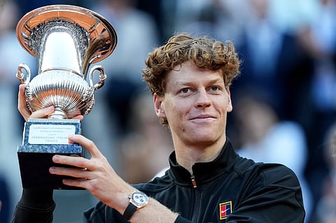 Jannik Sinner poses with the title