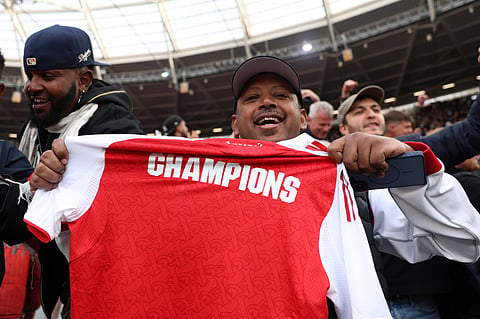 Arsenal fans celebrate with a shirt saying champions