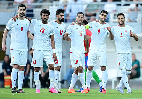 Iran players celebrate after scoring a goal against Gambia