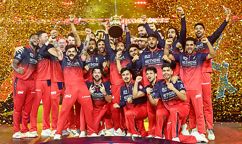 Royal Challengers Bengaluru players pose with the IPL trophy