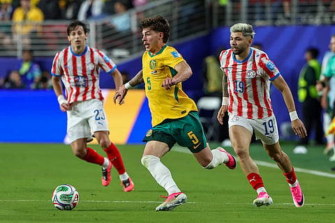 Players of Australia and Paraguay compete for the ball