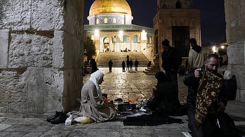Palestinian Muslims break their fast during the Muslim holy month of Ramadan outside the Dome of Rock at the Al-Aqsa Mosque compound in the Old City of Jerusalem, Saturday, March 16, 2024. 