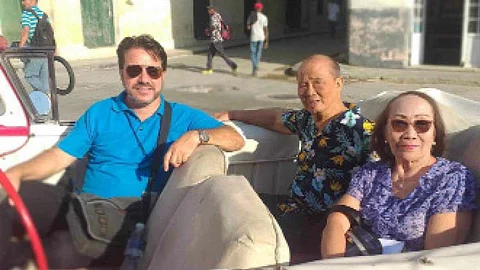 Cebuano lawyer Democrito Barcenas (center) and his wife Lourdes in an old convertible car with their guide.