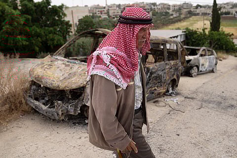 Fatahi Dawabsha, 82, walks past his family's vehicles that were torched during an attack by Israel settlers last month, in the West Bank village of Duma, Tuesday, April 30, 2024. 