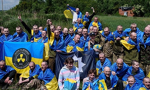 Ukrainian servicemen shout "Glory to Ukraine" after returning from captivity during POWs exchange in Sumy region, Ukraine, Friday, May 31, 2024. Ukraine returned 75 prisoners, including four civilians, in the latest exchange of POWs with Russia. It's the fourth prisoner swap this year, and 52nd since Russia invaded Ukraine. In all, 3 210 Ukrainian servicemen and civilians were returned since the outbreak of the war. 