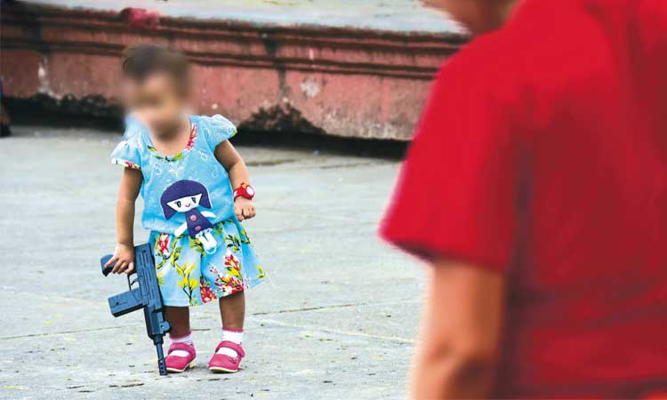 OF ALL THE TOYS. A toddler walks around Rizal Park brandishing a toy gun.