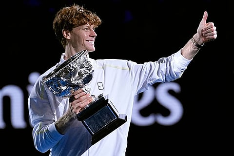 Jannik Sinner of Italy gestures as he carries the Norman Brookes Challenge Cup after defeating Alexander Zverev of Germany in the men's singles final at the Australian Open tennis championship in Melbourne, Australia, Sunday, Jan. 26, 2025.