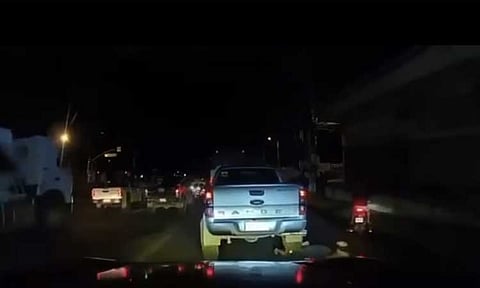 Screenshot of a viral video showing a man crawling under a vehicle during a traffic stop earlier this week. The incident, which occurred on the evening of April 22, 2025, in Buhangin, showed the man allowing himself to be run over by a vehicle, has raised concerns online about a possible scam.