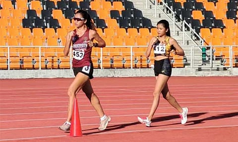 GOLDEN FINISH. University of the Philippines’ (UP’s) Juliana Talaro (left) pulls ahead of UST’s Azeneth Serat on her way to clinching a third straight title in the women’s 10-kilometer walkathon at the ICTSI Philippine Athletics Championships yesterday at New Clark City Athletic Stadium in Capas, Tarlac. 
