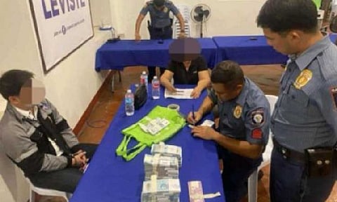 BRIBE TRY. Operatives of the Batangas police conduct an inventory of the pieces of evidence they seize from the arrested DPWH District engineer (seated, left) for attempting to bribe a Batangas lawmaker on Aug. 22, 2025. Senators Panfilo Lacson and Erwin Tulfo on Monday (Aug. 25, 2025) pressed for accountability over alleged corruption in flood control projects, calling on authorities to prosecute contractors, Department of Public Works and Highways officials, and politicians implicated in ghost and substandard infrastructure works.
(Photo courtesy of Batangas Police Provincial Office)
