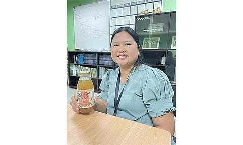 Tamarind Research, Development, and Extension head Warlina M. Guzman shows a sample of the tamarind juice produced by the Pampanga State Agricultural University. Photo by Ian Ocampo Flora