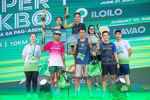 GRAB SUPER TAKBO 2025–DAVAO PODIUM FINISHERS. Elmer Bartolo and Aslia Hadji Nassef celebrate their 21K championship trophies alongside the other top three finishers in the men’s and women’s divisions at the Grab Super Takbo 2025–Davao, held on an out-and-back course at Davao Global Township in Matina, Davao City, on Saturday, November 8, 2025. 