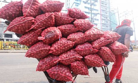 RED ONIONS. Porters haul a cart stacked with onions at Manila’s Divisoria Market on Nov. 3, 2023. The Department of Agriculture - Bureau of Plant Industry on Wednesday (Nov. 26, 2025) directed onion importers to explain the slower pace of red onion imports compared to yellow onions, as the country prepares for the holiday surge in demand. (PNA photo by Yancy Lim)