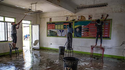 Volunteer students clean walls and ceilings at Biasong Elementary School in Talisay City on Saturday, Nov. 29, 2025.
