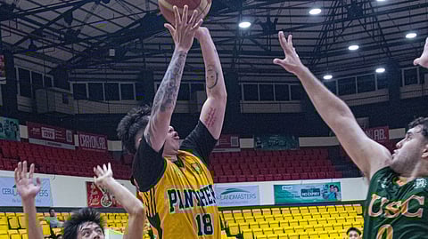 TOP PHANTER. Keaton Clyde Taburnal (18) of the University of Southern Philippines Foundation (USPF) springs up for a quick jumper against two University of San Carlos defenders at the Cebu Coliseum, where USPF closed out their Cesafi season with a 62-57 victory on Thursday, Dec. 4.  / 