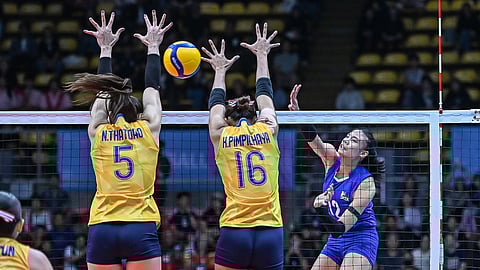 Angel Canino of Alas Pilipinas fires a crosscourt attack against Thailand’s Thatdao Nuek Jang (5) and Pimpichaya Kokram (16) during their Group A match in the 33rd SEA Games women’s volleyball tournament Thursday at Indoor Stadium Huamark in Bangkok. Thailand swept the Philippines, 25-11, 25-17, 25-16.