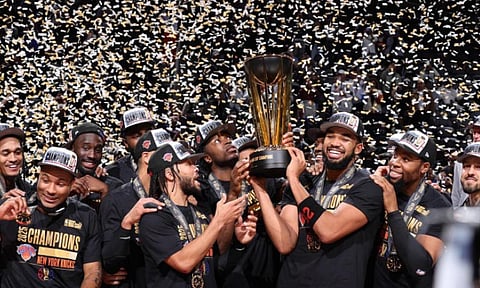CUP KINGS. NBA Cup MVP Jalen Brunson (center left) and Karl-Anthony Towns (center right) hoist the trophy as the New York Knicks celebrate their victory in Las Vegas. / 