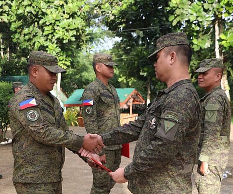 ZAMBOANGA. Lieutenant Colonel Rolando Vargas Jr., commander of the 53rd Infantry Battalion (2nd from right), leads the recognition rites of two enlisted personnel who excelled in their respective Non-Commissioned Officer Basic Courses during the flag-raising ceremony Monday, December 29, at Camp Major David Sabido, which houses the battalion headquarters in Guipos, Zamboanga del Sur. 