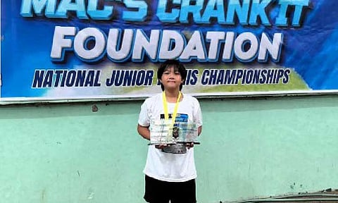 FAVORITE. Yuan Andre Torrente holds the U12 (champion) and U14 (runnerup) trophies at the MAC's Crankit event in December 2025. Torrente hopes to keep his form in the ongoing Zopiya Alexa Morales National Juniors Tennis Championships in Apalit, Pampanga. (Contributed photo)