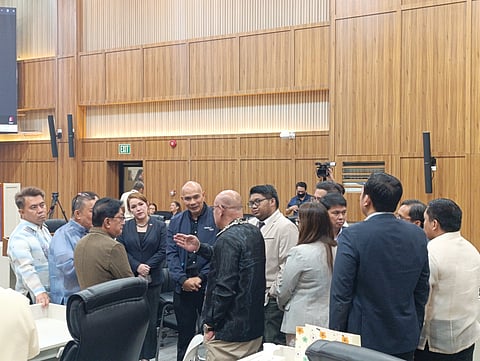 Davao Light and Power Company (Davao Light) president and chief operating officer (COO) Enriczar Tia peaks with city councilors during a session Tuesday, Jan. 20, 2026, at the Sangguniang Panlungsod, as lawmakers consider a resolution urging the Power Assets and Liabilities Management Corp. to refrain from reducing its power supply contract with the utility.