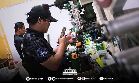 Bureau of Customs personnel inspect cigarettes found inside a warehouse in Mexico town on Wednesday. BOC photo