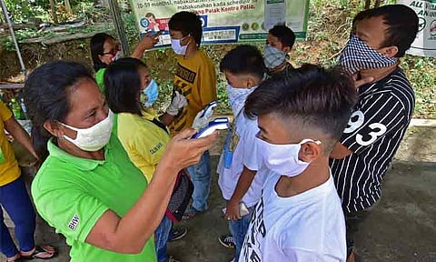 FRONTLINERS. In this file photo, several barangay health workers in Calinan, Davao City check the temperature of those entering the Task Force Davao checkpoint in Lacson. Health workers also pour alcohol to the hands of passengers as they enter. 