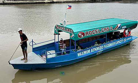 WATERWAY SAFETY. Balancing fares and footing, a young collector boards small boats along the Sandawa River in Davao City. The image comes amid a proposal at the City Council to require boat operators to secure clearances from the Maritime Industry Authority and the Philippine Coast Guard, following recent maritime accidents and rough sea conditions linked to the peak of the northeast monsoon.