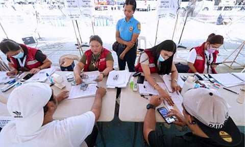CASH AID. Department of Social Welfare and Development personnel distribute PHP5,000 cash assistance to transport network vehicle service drivers at a payout center at Quezon Memorial Circle in Quezon City on March 24, 2026. DSWD Secretary Rex Gatchalian on Tuesday (April 7) said efforts are underway to shift to digital disbursement for the second tranche of cash relief assistance for public utility vehicle drivers. (PNA photo by Robert Oswald P. Alfiler)