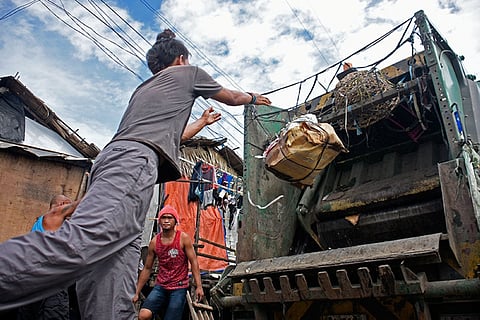 DAVAO. These men collect and carry garbage to the City Environment and Natural Resources Office (CENRO) truck at Isla Verde, Brgy. 23-C, Davao City.