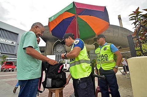 DAVAO. Police and Security officers stationed at the entrance to the San Pedro Cathedral in Davao City inspect the bags and remind churchgoers not to bring bags.
