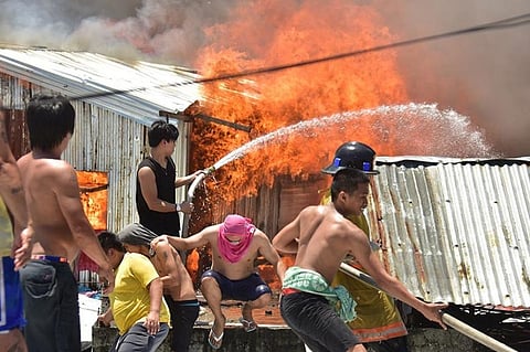 DAVAO. Residents of Isla Verde in Barangay 23-C trying to put out a fire razing some houses on August 16, 2019.
