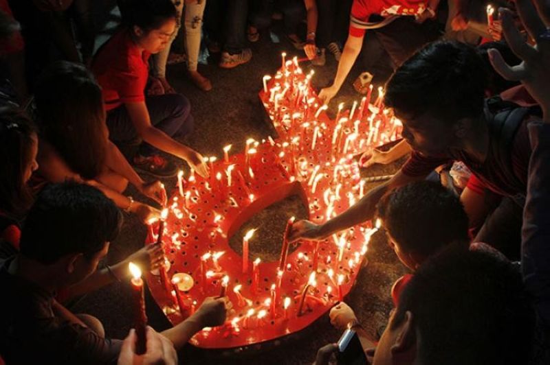 In this file photo, protesters light candles to protest the discrimination against people living with HIV.