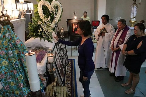 A RELATIVE OF MSGR. ESTEBAN Binghay blesses his remains with holy water during Tuesday's wake at the Chapel of Archdiocesan Shrine of Our Lady of Guadalupe Parish, Guadalupe, Cebu City. (SunStar Foto /  Amper Campaña)