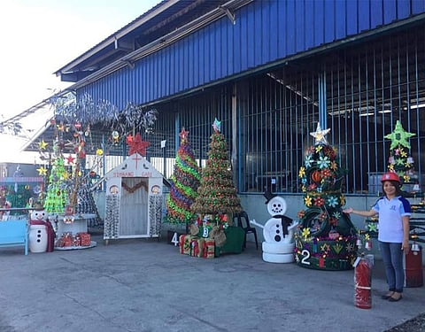 PAMPANGA. Far East Alcohol Corporation Pollution Control Officer Mercy Simon shows some of the entries for this year's "Reduce, Re-use, Recycle Christmas Tree Making" competition. (Princess Clea Arcellaz)