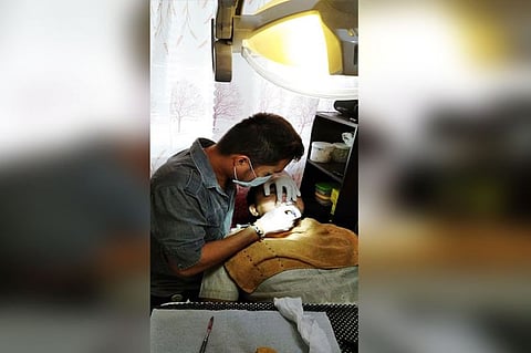 Dr. Jed Ariel Legislador performing a dental crown procedure with the writer. (Photo by Churchill Aguilar)