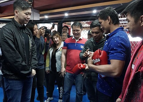 BAGUIO. Team Lakay fighters Eduard Folayang, Kevin Belingon, and Geje Esutaquio with coach mark Sangiao sign the gloves as a token to Benguet caretaker Eric Go Yap during his visit in their gym. (Photo by Roderick Osis)
