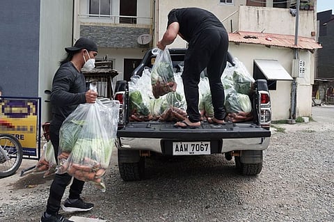 BENGUET. Former ONE Championship bantamweight world champion Kevin Belingon helps load fresh vegetables before they are distributed to the needy in La Trinidad, Benguet on Friday. Photo by Roderick Osis